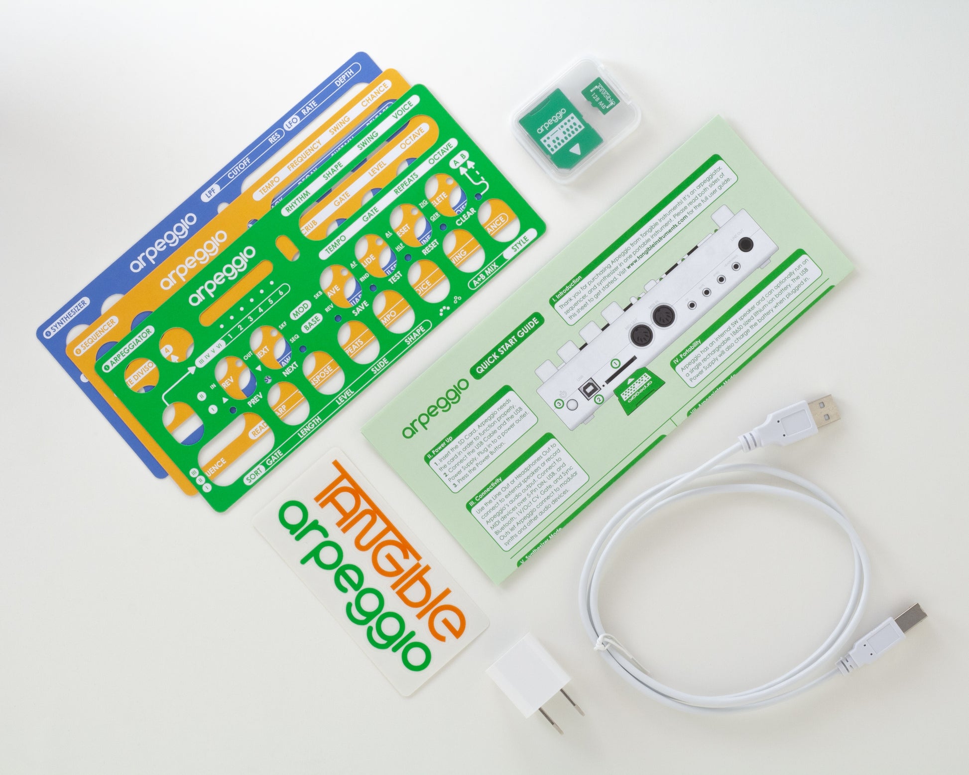 All of the accessories that come with Arpeggio: the three overlays, SD-Card, USB cable and power supply, quick start guide, and stickers.